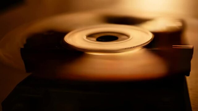 Close up of a record player's turntable, followed by a close up of a roll of tape and a cd player's turntable.