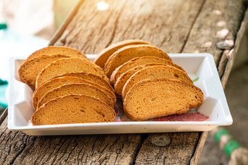 Crispy rusk, Biscuits cake rusk over wooden background , a crunchy snack infused with traditional spices, perfect for tea or coffee. A delightful treat for your mornings or tea time