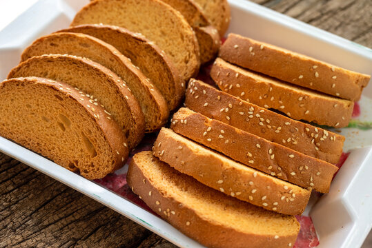 Crispy rusk, Biscuits cake rusk over wooden background , a crunchy snack infused with traditional spices, perfect for tea or coffee. A delightful treat for your mornings or tea time