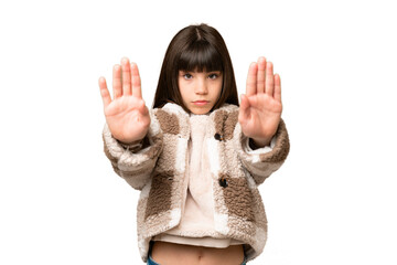 Little girl over isolated green chroma key background making stop gesture and disappointed