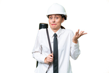 Young architect woman with helmet and holding blueprints over isolated background having doubts while raising hands