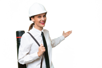 Young architect woman with helmet and holding blueprints over isolated background extending hands to the side for inviting to come