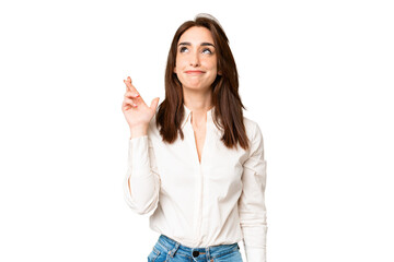 Young caucasian woman over isolated chroma key background with fingers crossing and wishing the best