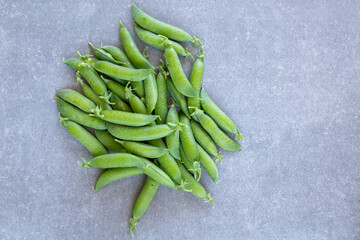 green pea pods on gray background