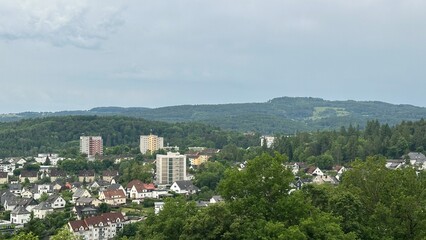Obraz premium Panoramic view of the charming town of Herborn, Germany, captured from the top of the Aussichtsturm Dillblick observation tower. The image reveals a picturesque blend of historic rooftops, green hills