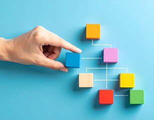 Hand arranging colorful wooden blocks in a hierarchy