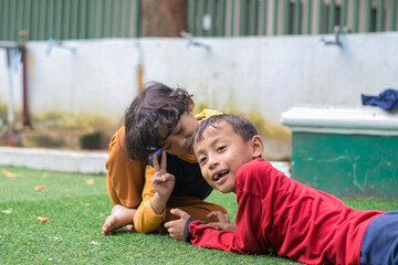 Portrait of two little children at park full of grass