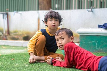 Portrait of two little children at park full of grass