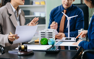 business team signs contract on clean energy and sustainable property development, surrounded by...