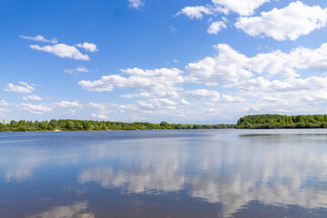 A beautiful lake with clouds reflected in the water under a blue sky