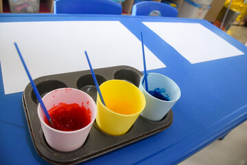 Set of different cute toys in children's playground. Preschool building exterior with playground and toys on a sunny day