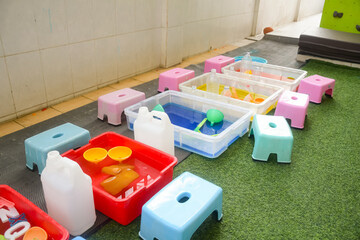 Set of different cute toys in children's playground. Preschool building exterior with playground and toys on a sunny day