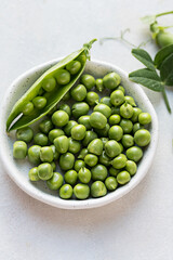 Close-up fresh green peas beans in a white plate. Macro photography