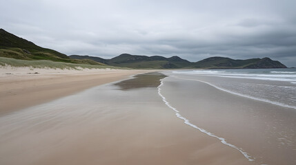 Empty beach with gentle waves and moody sky, soft sand stretching along shoreline with distant green hills under cloudy weather creating calm and peaceful atmosphere