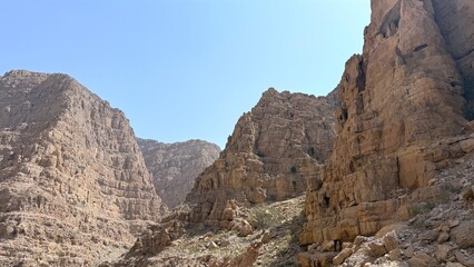 Sediment cliffs rise vertically with dramatic vertical cuts, layered faces telling story of ancient...