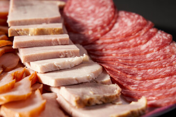 sliced meat on a plate, sausage, ham, pork. Close-up.