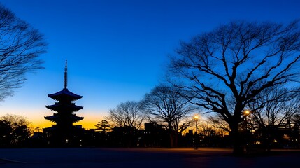 Serene Sunset Silhouette: Japanese Pagoda and Bare Trees