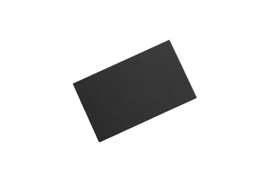 A slightly angled, dark gray rectangular object with a subtly textured surface, appearing almost like a flat, matte stone or piece of electronics.  Tiny flecks of color are visible around its edges