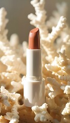Elegant lipstick standing upright against a textured coral background. Fashionable arrangement