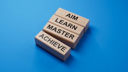 Aim Learn Master Achieve symbol. Concept word Aim Learn Master Achieve on wooden blocks.Business and Aim Learn Master Achieve concept.3D rendering on blue background.