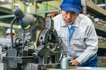 工場で機械を操作する男性作業員