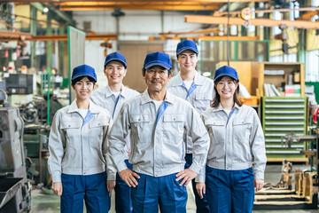 工場に並ぶ作業員グループの集合写真