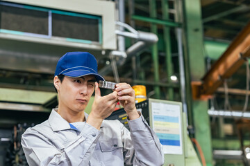 工場で製品を検品する男性作業員