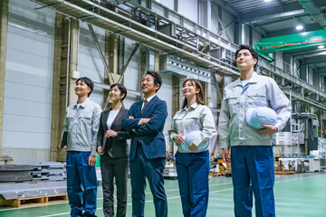 工場の中に立つ作業スタッフのグループ