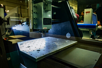 Close up of a CNC Milling Machine in a Metalwork Shop with Industrial Lighting and Shadows © dizfoto1973