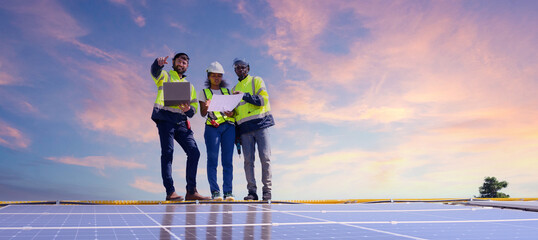 A team of engineers is laying out the installation of an outdoor solar panel system. Installing solar cells on the roof. Solar panels on the roof Workers install eco-technology photovoltaic power plan © eakarat
