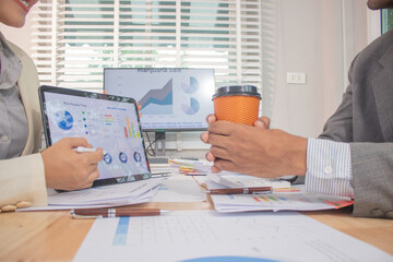 Two experts in a modern Australian conference room analyze charts, discuss strategies and present financial data to plan growth, profits and success.