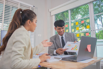 Two experts in a modern Australian conference room analyze charts, discuss strategies and present financial data to plan growth, profits and success.