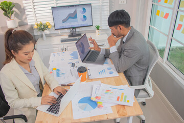 Two experts in a modern Australian conference room analyze charts, discuss strategies and present financial data to plan growth, profits and success.