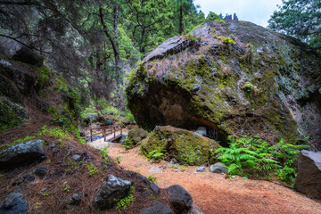 Wanderweg in der Caldera de Taburiente vorbei an großen Felsen über Holzbrücken