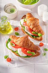 Homemade and golden french croissant with cheese, basil and tomatoes.