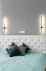Close-up of the headboard of the bed is in an elegant modern bedroom featuring natural color tones....