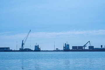 Harbor silhouette with cargo ships and cranes. This image emphasizes the industrial aspect of maritime operations, ideal for themes related to shipping and logistics. Black Sea, Turkey.