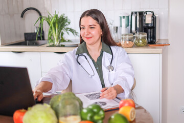 female nutritionist consulting patients at a table with healthy vegetables and fruits using a computer and a tablet. health concept, medical services.