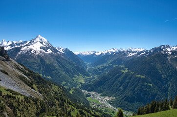 Naklejka premium large panorama towards Amsteg in Switzerland with blue sky in spring