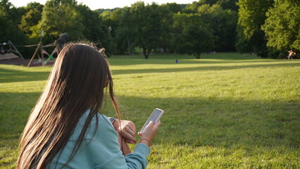 young woman with mobile phone in the park
