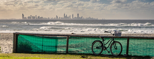 A bicycle on Kirra Beach with the Surfers Paradise skyline on the horizon. Queensland, Australia.