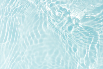 Blue water with ripples on the surface. Defocus blurred transparent blue colored clear calm water surface texture with splashes and bubbles. Water waves with shining pattern texture background.