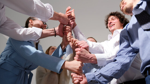 Young marketing professionals are playing a fun leadership development game. A group of people is standing in a circle