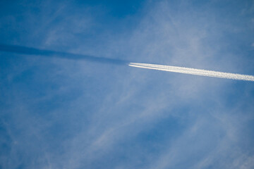 Bizarre sky sights with shadow of airplane trail in blue sky