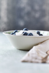 Healthy breakfast bowl with yogurt, blueberries and granola on a bright background. Copy space.