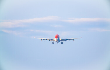 The plane lands over the sea at Phuket airport. A passenger plane lands on Mai Khao Beach, a popular tourist attraction.