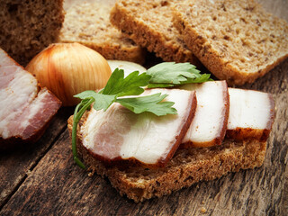 Traditional Smoked Pork Lard Slices on Dark Rye Bread with Fresh Parsley and Onion