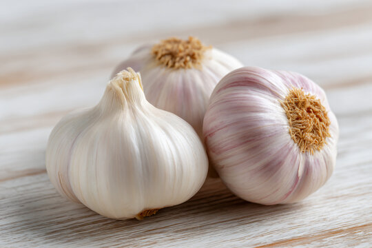 two garlic bulbs on a wooden table - Powered by Adobe