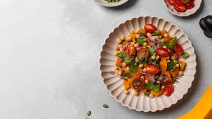 Fresh chickpea and pumpkin salad with tomatoes and herbs for healthy eating. Copy space