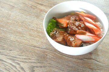 grilled saba fish or mackerel topping crab stick and lettuce on japanese rice in bowl